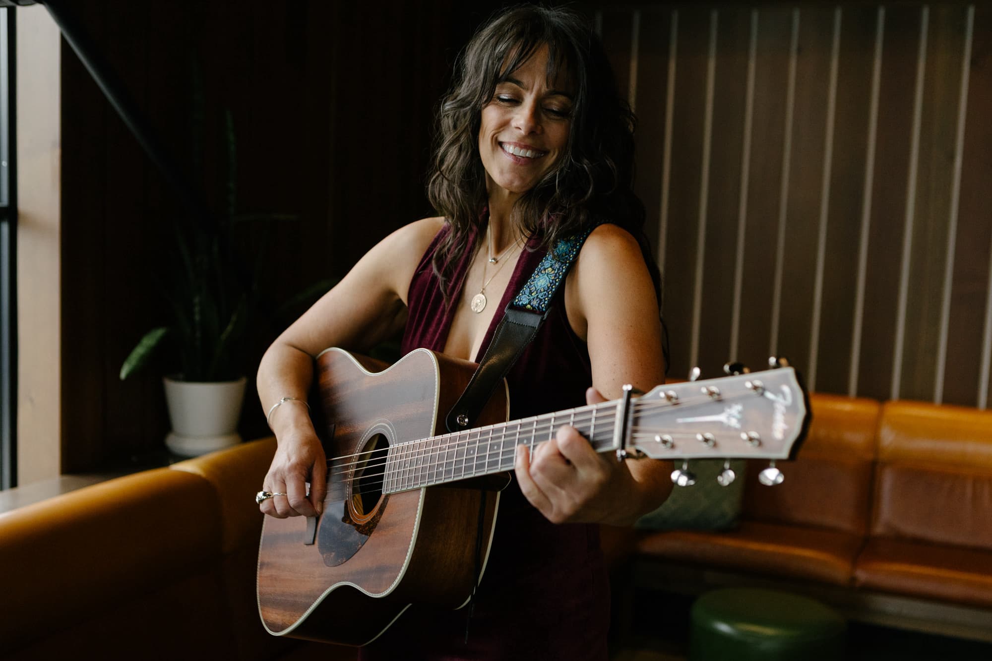 Maggie, founder of Whitefish Music Scene, playing guitar and smiling